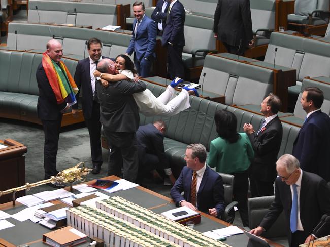 Liberal MP Warren Entsch lifts up Labor MP Linda Burney as they celebrate the passing of the Marriage Amendment Bill. Picture: AAP