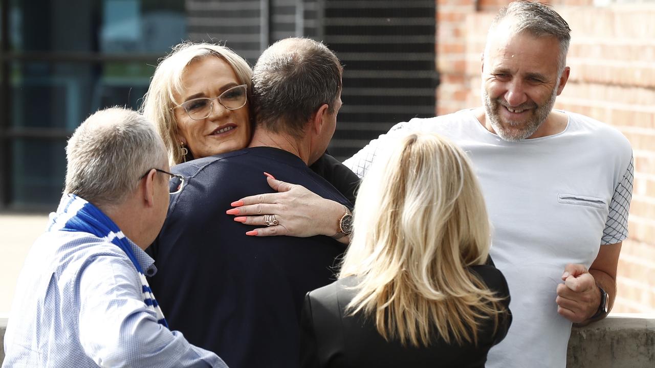 There were hugs all around to celebrate the milestone. (Photo by Darrian Traynor/Getty Images)