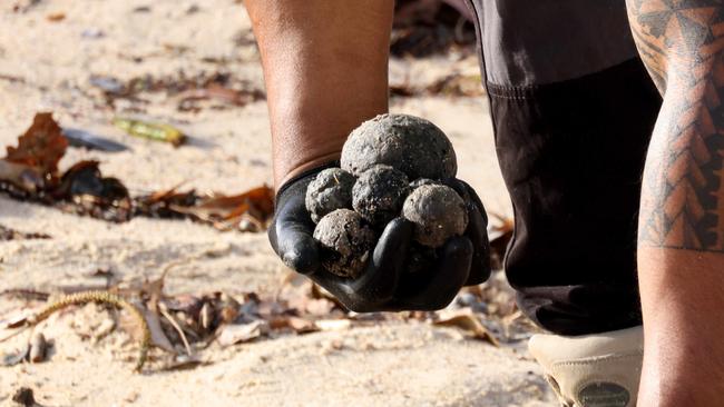 SYDNEY, AUSTRALIA - NewsWire Photos OCTOBER 16, 2024: Council workers clean up what Randwick council describes as possible tar balls that have washed up on Coogee Beach. Coogee Beach has been closed until further after mysterious, black, ball-shaped debris was located washed along the length of the beach.Picture: NewsWire / Damian Shaw