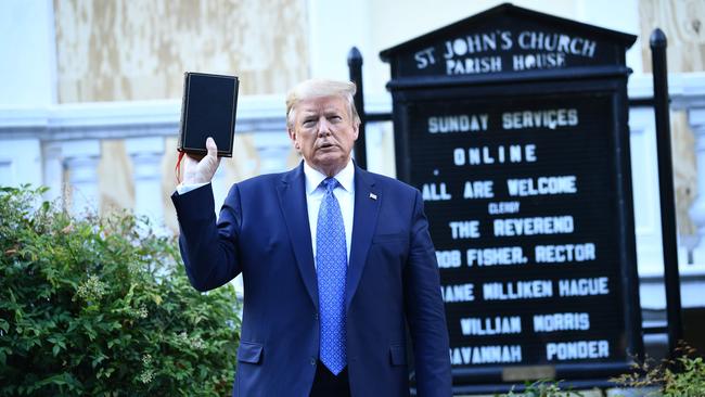 US President Donald Trump holds up a bible in front of St John's Episcopal church after walking across Lafayette Park from the White House.