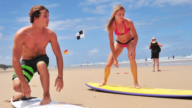 Tennis player Daniela Hantuchova gets surfing lessons from pro surfer Julian Wilson at Coolum Beach in 2012.