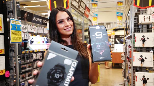 Mia Cygler at JB Hi Fi Cairns Central holds a Garmin watch and a GoPro Hero 9. Picture: Brendan Radke