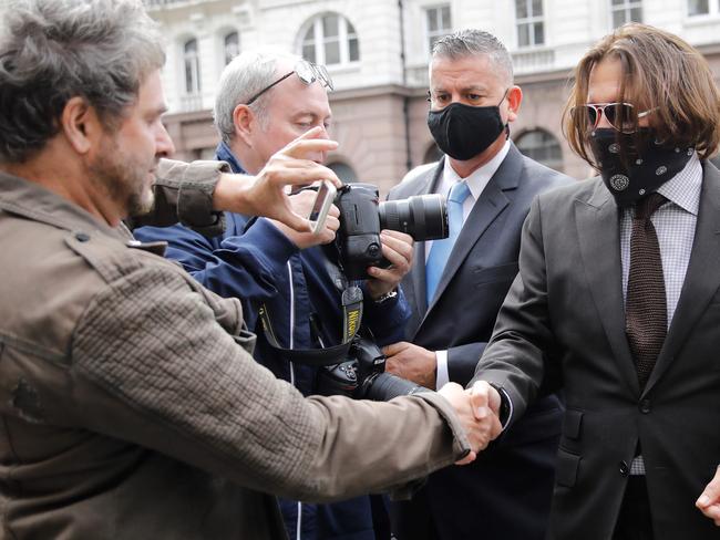 Johnny Depp shakes hands with a fan outside court. Picture: AFP