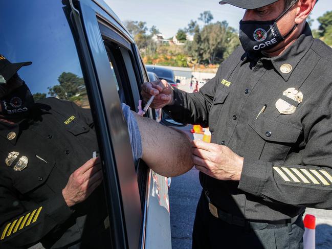 Los Angeles Fire Assistant Fire Chief Ellsworth Fortman, right, administers a COVID-19 vaccine in Los Angeles. Picture: AFP