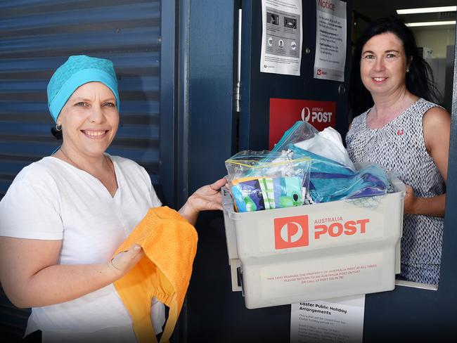 What started as an idea to sew scrub hats for nurses by Sunshine Coast resident Julie Alison(left) quickly grew to cover 31 locations and a following of 2508 people in a Facebook group in just under a week. Julie Alison has received help from many community members, and now the Sippy Downs post office manager has leant a helping hand by giving them their very own post box to send the scrub hats. Pictured with Julie is Joanne Griffin-Klazema, acting officer in charge, Sippy Downs post office. Photo Patrick Woods / Sunshine Coast Daily.