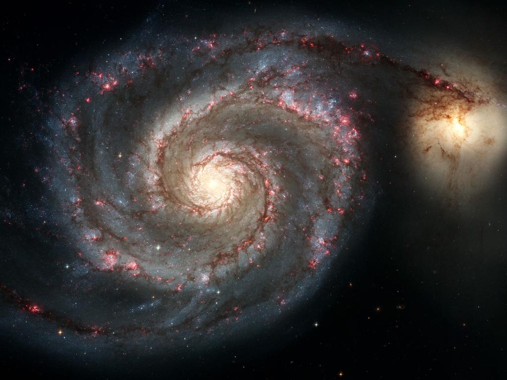 The spiral galaxy M51, also known as the Whirlpool Galaxy, and its companion galaxy (R).