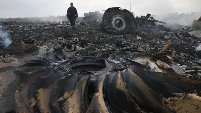 An emergency services member walks among the wreckage at the crash site. Picture: Reuters