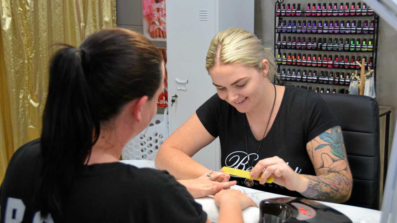 Brodie doing nails on a happy customer. Picture: Maddelin McCosker