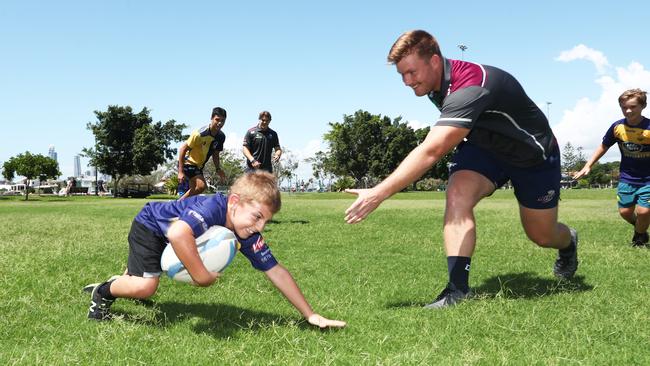 Queensland Reds Rugby Player Harry Hoopert plays with Gold Coast Eagles junior Alfie Lawrie as the Reds visited at Gold Coast Eagles at Southport. Photograph: Jason O'Brien