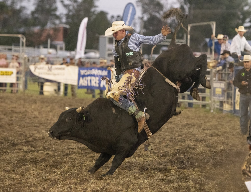 Robert Hicks rides high in the open bullride at the Lawrence Twilight Rodeo. Picture: Adam Hourigan