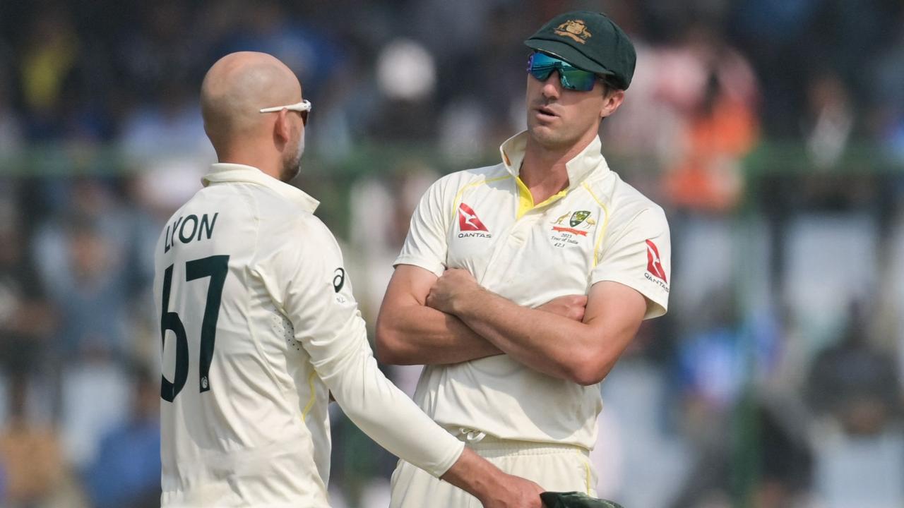 Australia's captain Pat Cummins (R) speaks with Nathan Lyon.