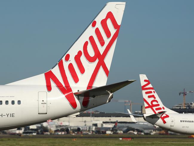 The Virgin Australia Holdings Ltd. logo is displayed on the tails of a Boeing Co. 737-800, left, and a Boeing Co. 737-8FE aircraft preparing to take off at Sydney Airport in Sydney, Australia, on Monday, Feb. 8, 2016. Virgin Australia is scheduled to announce half-year earnings on Feb. 11. Photographer: Brendon Thorne/Bloomberg