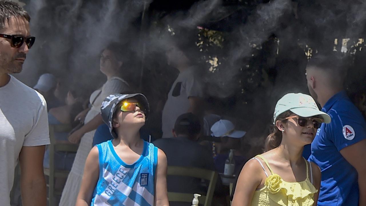 Tourists are refreshed under a mist of cold water during a heatwave on July 20, 2023 in Athens, Greece. Picture: Milos Bicanski/Getty Images