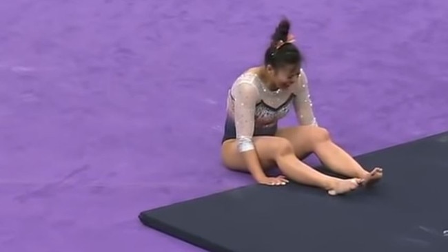 The gymnast writhes in pain.