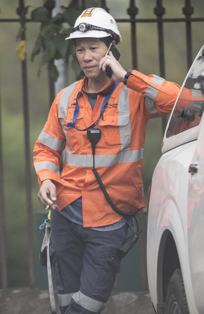 One of the rail workers talking on the phone.