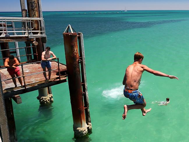 CREDIT: GETTYONLINE USE ONLYADELAIDE, AUSTRALIA - JANUARY 13: A teengager jumps off the Glenelg jetty during a heat wave at Glenelg Beach on January 13, 2014 in Adelaide, Australia. Temperatures are expected to be over 40 degrees celsius all week with health authorities warning the young and elderly to remain indoors.  (Photo by Daniel Kalisz/Getty Images)