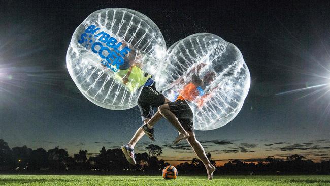 10/5/14 Dan Cairns and Nathan Swan playing soccer in the bubbles on the christies beach high school oval.