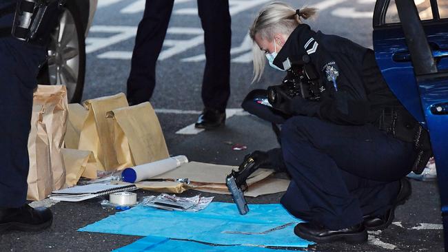 Police forensics examine a gun. Picture: Jason Edwards