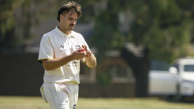 Premier Cricket: Camberwell’s Andrew Gorvin shines the ball. Picture: Valeriu Campan