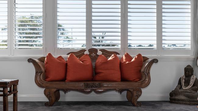 An antique hand-carved bench watched over by a statue of Buddha. Picture: Flavio Brancaleone