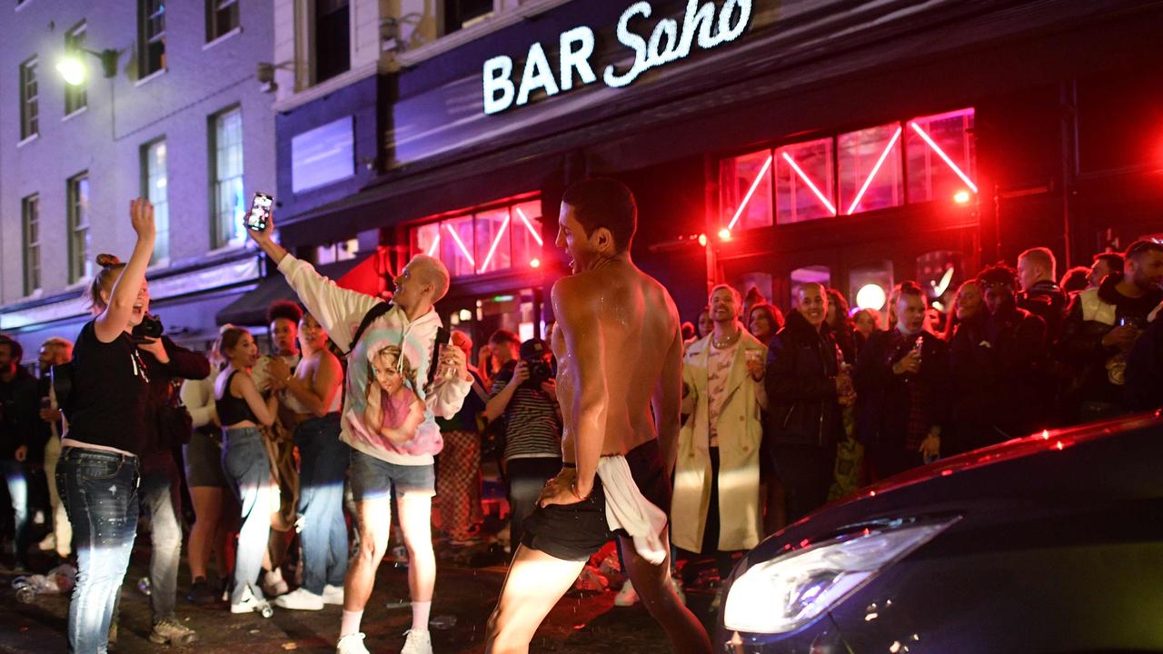 A car tries to drive along a street filled with revellers drinking in the Soho area of London. Picture: AFP