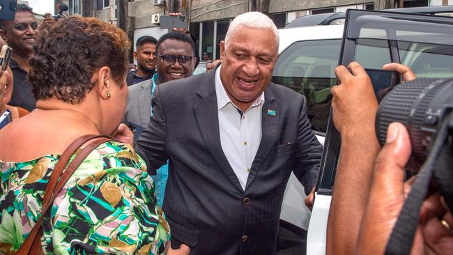 Fiji's former prime minister Frank Bainimarama (C) reacts with his supporters as he leaves the Magistrates Court in Suva in March. Picture: AFP.