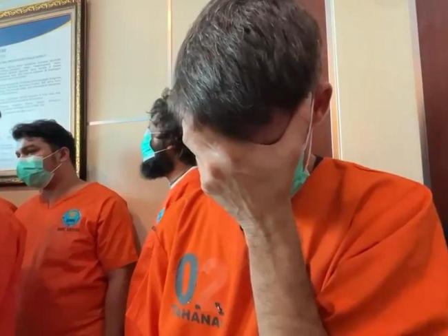 Aussie accused hides face at police show drug haul
