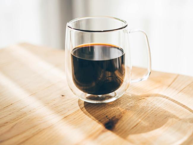 Coffee in a glass at wooden table.