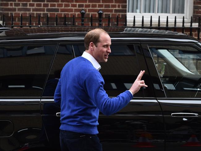 Britain's Prince William, Duke of Cambridge, gestures with two fingers, as he prepares to drives his wife Catherine, Duchess of Cambridge and their newly-born daughter, their second child, away from the Lindo Wing at St Mary's Hospital in central London, on May 2, 2015. The Duchess of Cambridge was safely delivered of a daughter weighing 8lbs 3oz, Kensington Palace announced. The newly-born Princess of Cambridge is fourth in line to the British throne. AFP PHOTO / LEON NEAL