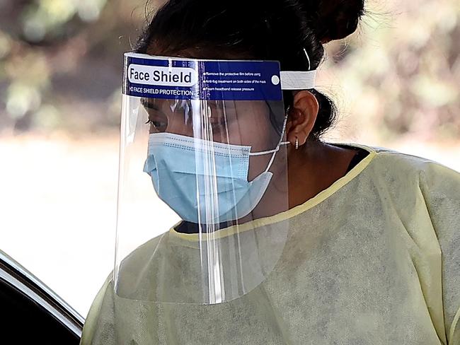 PERTH, AUSTRALIA - MAY 03: A health worker carries out COVID-19 testing at the Joondalup drive-through clinic on May 03, 2021 in Perth, Australia. Perth is on alert after a hotel quarantine security guard from the Pan Pacific hotel and two of his housemates tested positive for COVID-19 on the weekend. While WA Premier Mark McGowan has not imposed a lockdown in response to the recent cases, restrictions requiring the use of face masks outdoors have been reintroduced. (Photo by Paul Kane/Getty Images)