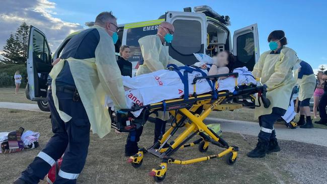 An injured swimmer is loaded into an ambulance after being bitten y a shark at Ocean Grove. Picture: Peter Hobbs/Facebook