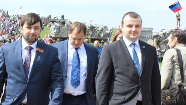 Left to right: Separatist leader of the Donetsk region Denis Pushilin, promoter of the Prizm cryptocurrency Alexi Muratov, and Ouroborous crypto promoter Alexandr Lavrentyev. The flag of the Donetsk People's Republic flies in the background. Photo: Centre for Information Resilience.