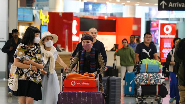 People are seen arriving at the Sydney International Airport from Hong Kong. Picture: NCA Newswire / Gaye Gerard