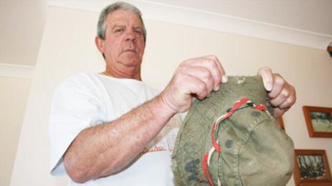 Warren Pearson shows the shrapnel holes in the bush hat he was wearing the day he stepped on a booby trap at Vietnam in 1966. Picture: File