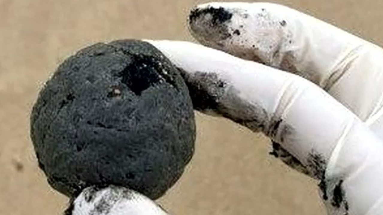 Coogee Beach has been closed until further notice after mysterious, black, ball-shaped debris was found washed up on the beach. Picture: Nine News