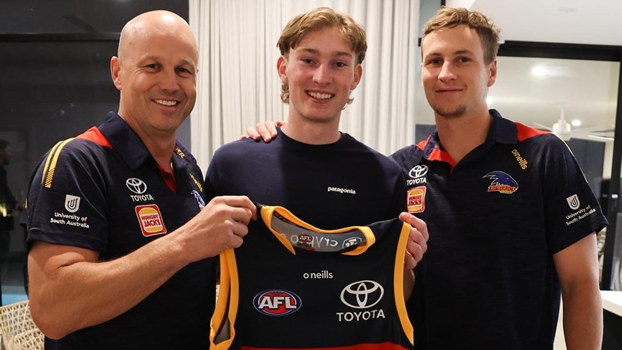 Matthew Nicks and Jordan Dawson presented Max Michalanney with his Crows guernsey. Picture: Adelaide FC/Twitter