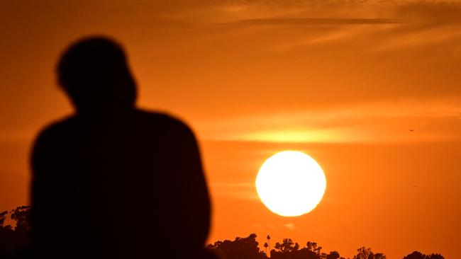 A man watches the setting sun in LA, California, as at least 13 US states braced for scorchers this week as the deadly heatwave in southwestern US was set to spread. Picture: AFP