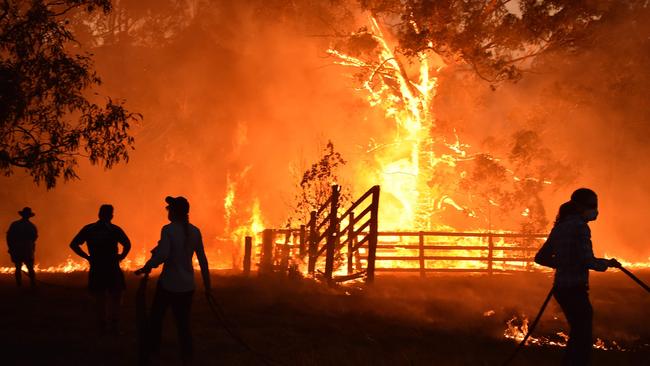 Residents defend a property from a bushfire at Hillsville near Taree, 350km north of Sydney on November 12, 2019. - A state of emergency was declared on November 11 and residents in the Sydney area were warned of "catastrophic" fire danger as Australia prepared for a fresh wave of deadly bushfires that have ravaged the drought-stricken east of the country. (Photo by PETER PARKS / AFP)