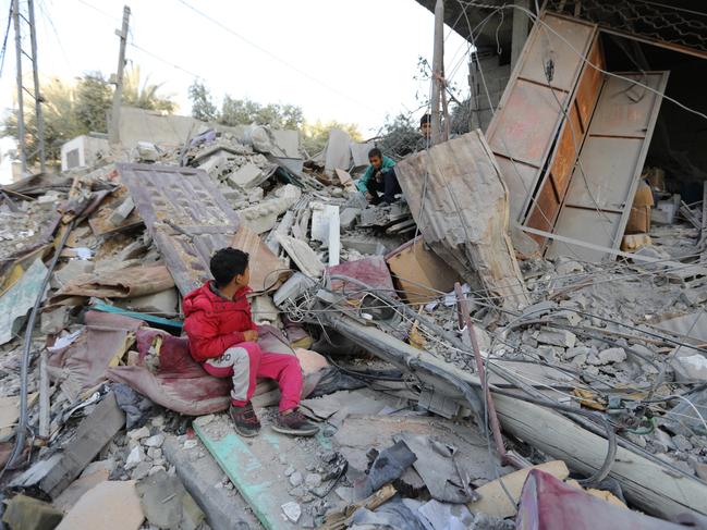 Two boys sit amongst the rubble as people inspect damage and recover items from their homes following Israeli air strikes on April 02, 2024 in Rafah, Gaza. Picture: Ahmad Hasaballah/Getty Images