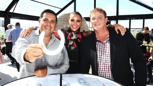 Owners of Bondeiger Adam Mizzi and Laurence Eales with face of the Cup Jess Dover and their barrier 2 horseshoe at the Adelaide Cup barrier draw in the new AAMI marquee at Morphettville racecourse on Tuesday. Picture: AAP/Mark Brake