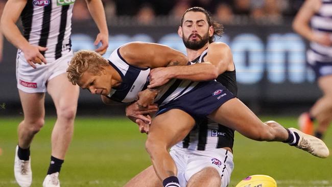 Quinton Narkle is wrapped up by Collingwood ruckman Brodie Grundy. Picture: AAP Image/Michael Dodge.