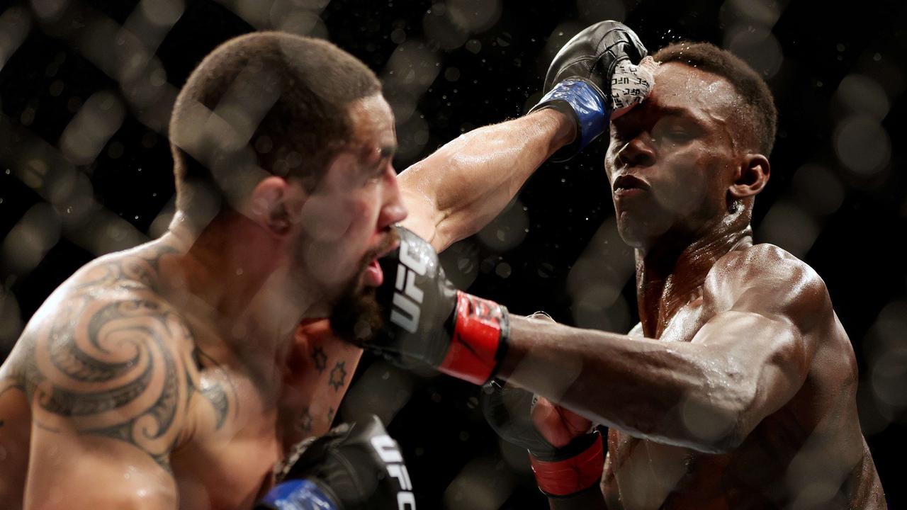HOUSTON, TEXAS - FEBRUARY 12: Israel Adesanya (R) of Nigeria exchanges strikes with Robert Whittaker of Australia in their middleweight championship fight during UFC 271 at Toyota Center on February 12, 2022 in Houston, Texas. Carmen Mandato/Getty Images/AFP == FOR NEWSPAPERS, INTERNET, TELCOS &amp; TELEVISION USE ONLY ==