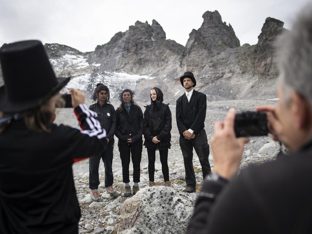 Activists pose in dark clothing in front of the 'dying' glacier of Pizol mountain in Wangs, Switzerland. Picture: AP