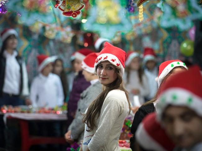 Muted festivities ... Young Christians gather to sell Christmas merchandise made by displaced Iraqi Christian children to buy supplies for the unfinished buildings and makeshift shelters their families must live in. Source: Getty