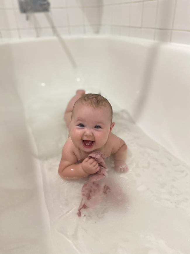 Isla Mae Strachan cooling off in the bath after another humid Territory day. Picture: Jennifer