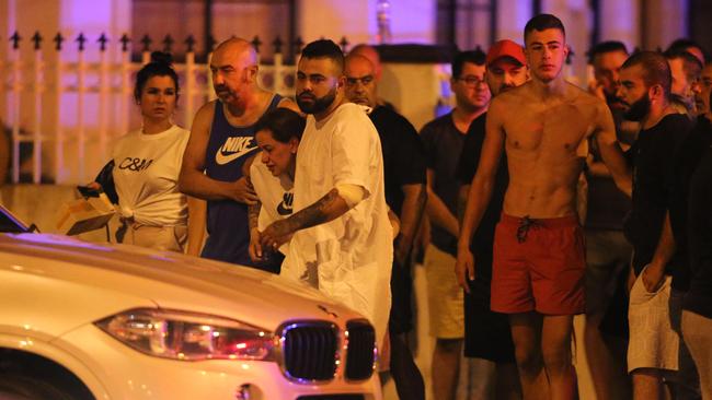 Mourners, including Maghnie’s son Abbas, at the scene of the shooting. Picture: Wayne Taylor