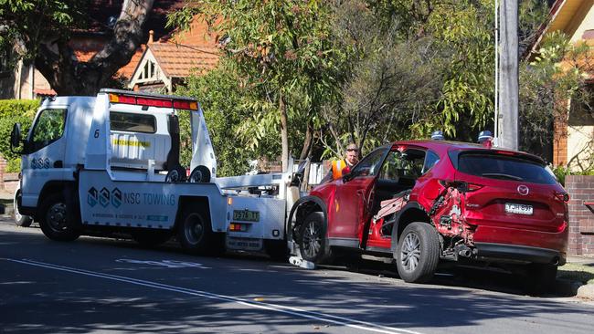 Police are seen with the tow truck driver preparing the car to be towed, which hit a 25-year-old woman who was sitting at the bus stop on Victoria Rd and the corner of Westbourne St, Drummoyne about 8am. Picture: NCA Newswire / Gaye Gerard