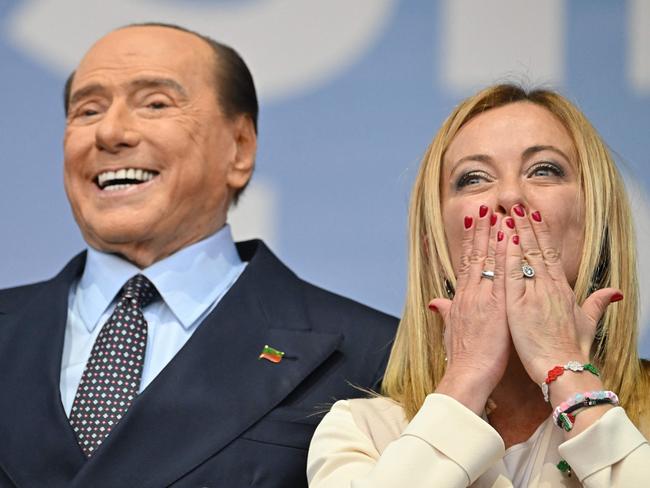 Forza Italia leader Silvio Berlusconi and Brothers of Italy leader Giorgia Meloni stand on stage on September 22, 2022 during a joint rally of Italy's right-wing parties Brothers of Italy (Fratelli d'Italia, FdI), the League (Lega) and Forza Italia at Piazza del Popolo in Rome, ahead of the September 25 general election. (Photo by Alberto PIZZOLI / AFP)