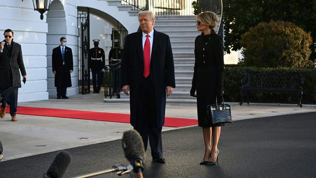 Donald Trump and wife Melania speak to the White House press pack as they depart Washington DC on January 20. Picture: AFP