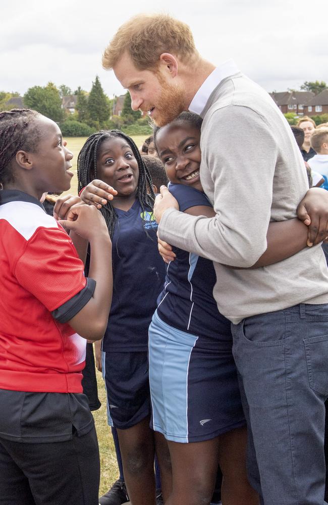 Prince Harry receives a hug from a young girl as he meets pupils during his visit to The Rugby Football Union All Schools Program in 2019. Picture: Arthur Edwards – WPA Pool/Getty Images